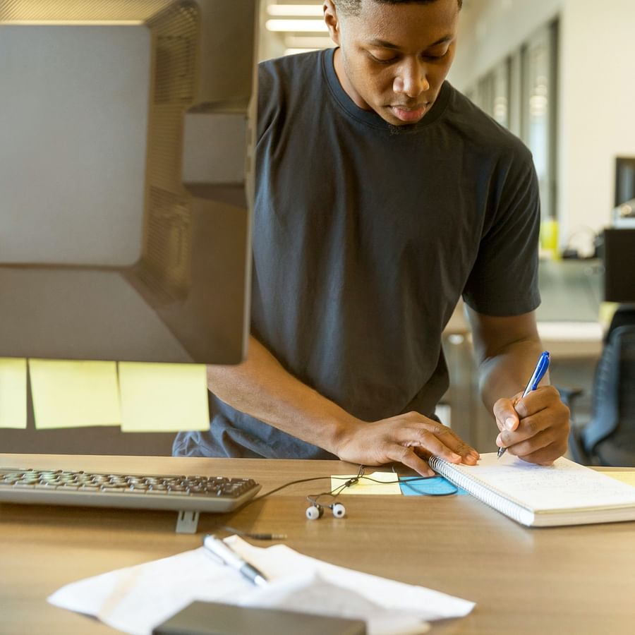 Person diligently writing their education resume